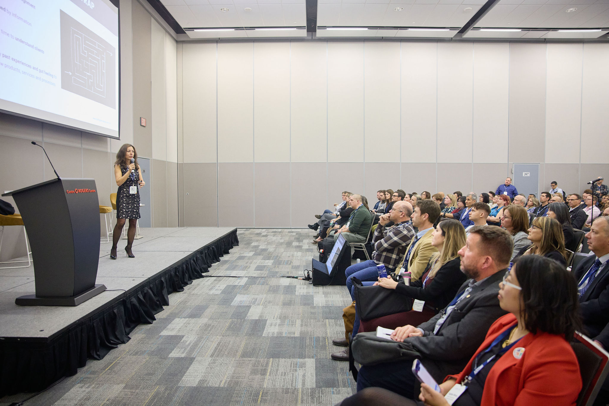 woman standing on a stage with a crowd looking at her